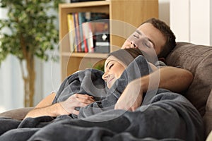 Couple sleeping together on a couch at home