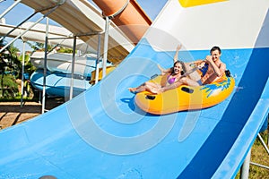 Couple sliding down a water slide