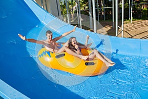 Couple sliding down a water slide