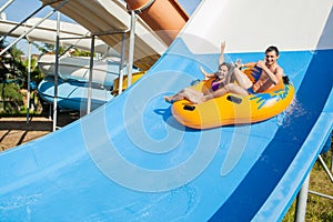 Couple sliding down a water slide