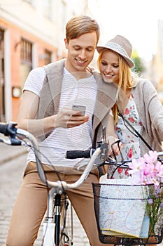 Couple with smartphone and bicycles in the city