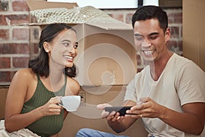 Couple, smartphone and boxes in new house and happy, relax and browse in real estate for mortgage and property photo