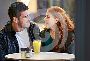 Couple, smile and eye contact in restaurant with love, romance and affection on anniversary date. Romantic, man and