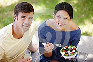 Couple, smile and healthy with salad in park for picnic, nutrition with diet from above. Man, woman and lunch or eating