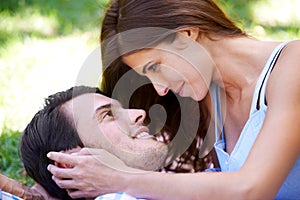 Couple, smile and picnic on grass with embrace for bonding, love and sunshine in park outdoors. Happy, man and woman in