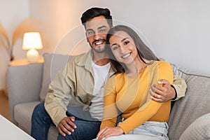 Couple smiling and embracing on couch at clinic