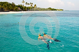 Couple snorkel in crystal water in Maldives