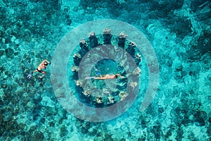 The couple snorkeling near the famous place on Gili Meno Island, Indonesia. Aerial view from drone. Underwater tourism in the ocea photo