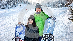 Couple snowboarders standing on ski slope