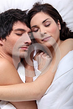 Couple snuggling in bed