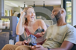 Couple On Sofa At Home Together Playing Computer Game With Woman Winning