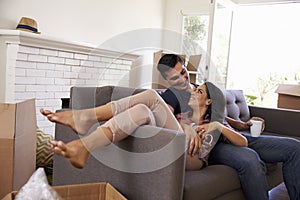 Couple On Sofa Taking A Break From Unpacking On Moving Day