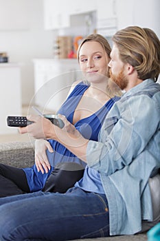 Couple on sofa with tv remote