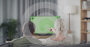 Couple, sofa and watching tv on green screen with remote for movies or film choice and streaming service at home. Back