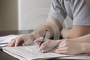 Couple Solving Sudoku In Newspaper At Desk