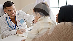 Couple and son having medical consultation writing on notebook at clinic