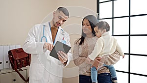 Couple and son having medical consultation writing on touchpad at clinic