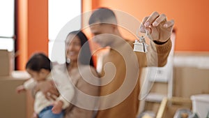 Couple and son hugging each other holding keys at new home