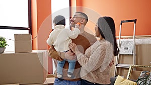 Couple and son hugging each other standing at new home