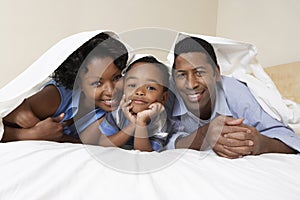 Couple With Son Lying Underneath Sheet