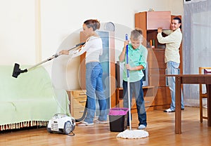 Couple with son vacuuming together