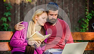 Couple spend leisure reading. Couple with book and laptop search information. Information source concept. Share or