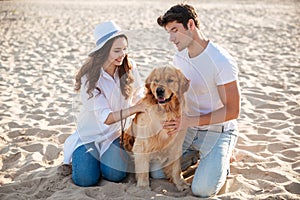 Couple spending time on the beach with their dog