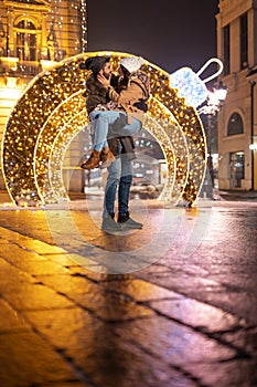 Couple spending time outdoors in decorated city streets for Christmas