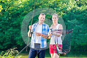 Couple sport fishing bragging with fish caught