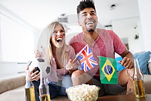 Couple, sports, entretainment and happiness concept. Happy couple cheering at home