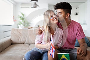 Couple, sports, entretainment and happiness concept. Happy couple cheering at home
