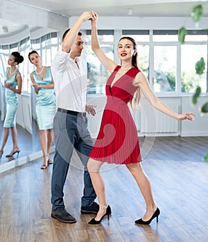 Couple in stage costumes learns boogie woogie dancing during individual lesson