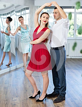 Couple in stage costumes learns boogie woogie dancing during individual lesson