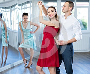 Couple in stage costumes learns boogie woogie dancing during individual lesson