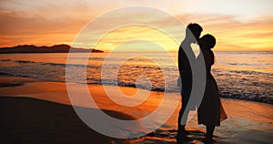 Couple stand on sunset beach