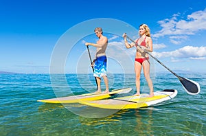 Couple Stand Up Paddle Surfing In Hawaii