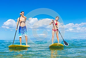 Couple Stand Up Paddle Surfing In Hawaii