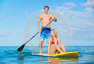 Couple Stand Up Paddle Surfing In Hawaii photo