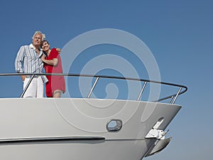 Couple Standing With Arm Around On Bow Of Yacht