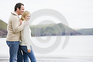 Couple standing on beach smiling