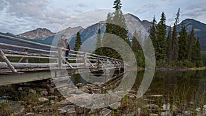 Couple standing on a bridge romantically looking out with beautiful landscape photo