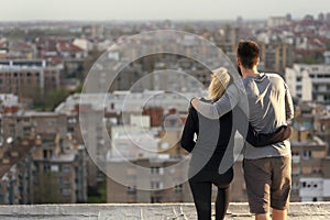 Couple standing on a building rooftop terrace