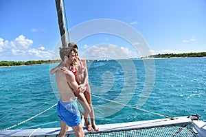 Couple standing in catamaran cruising in caribbean sea