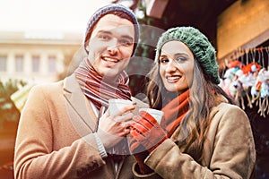 Couple standing on Christmas market in front of gift stall