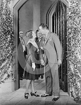 Couple standing in front of a door and having a fight