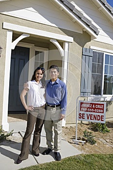 Couple Standing In Front Of New House