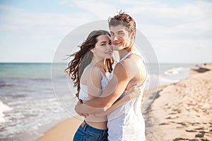 Couple standing and hugging on the beach