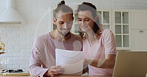 Couple standing indoors reading good news in document feels satisfied