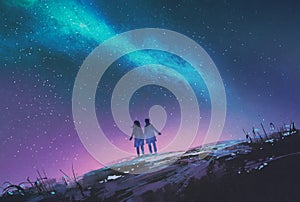 Couple standing looking Milky Way galaxy