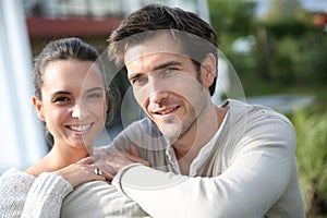 Couple standing outside in front of their house